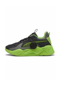 Baskets avec une tige en mesh noir, accents vert fluo, semelle texturée et un grand talon strié. Comprend une étiquette attachée aux lacets.