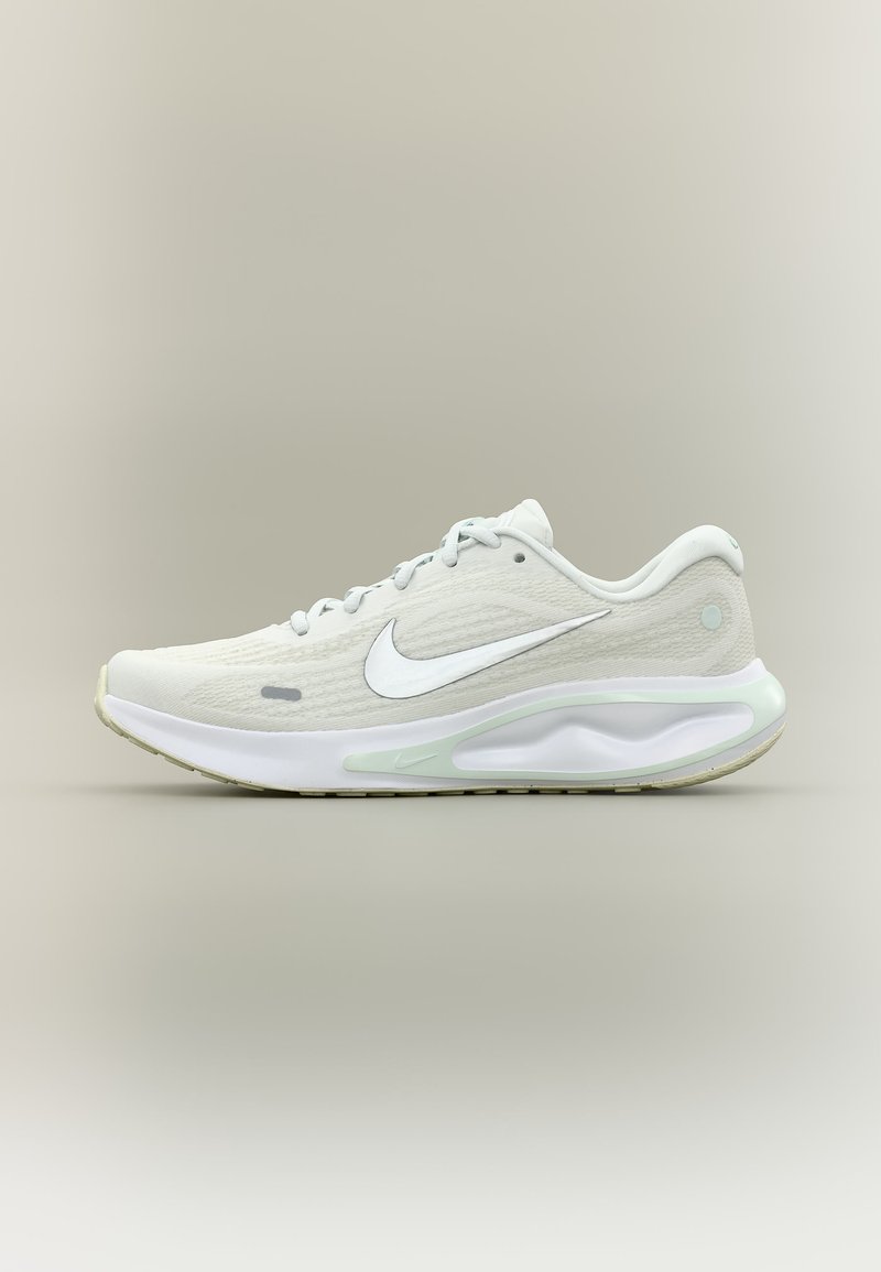 Λευκό αθλητικό παπούτσι Nike για τρέξιμο με ορατή σόλα με αερόσακο, πάνω μέρος από δίχτυ, κορδόνια και λογότυπο Swoosh σε ουδέτερο φόντο.