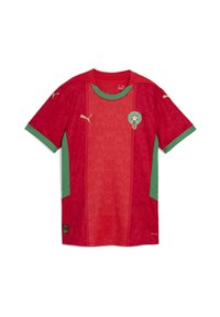 Czerwona i zielona koszulka piłkarska z krótkim rękawem, ozdobiona wzorami w gwiazdki, logo Puma oraz emblematem drużyny z zieloną obwódką na klatce piersiowej.