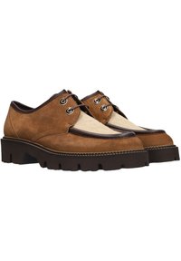 Bruine suède schoenen met een gladde lichtbeige accent. Rond neu, bruine rubberen zool met een geribbelde textuur en metalen oogjes voor de veters.