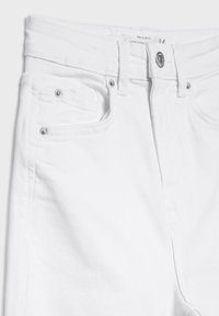 White denim jeans featuring a slim fit design, a button closure, and silver hardware accents. Includes front pockets and visible stitching.