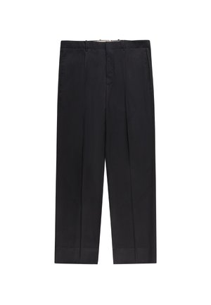 Zwarte, op maat gemaakte pantalon met ceintuurlussen, voorplooien en zijzakken, plat gelegd tegen een witte achtergrond.