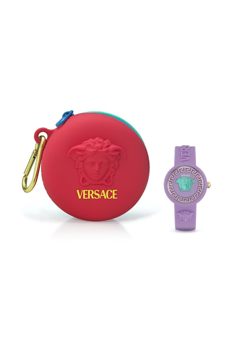 Portamonete in silicone rosso con hardware dorato, con logo Medusa in rilievo; orologio viola adiacente con quadrante rotondo e motivo a chiave greca.
