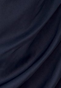 Námořnická modrá látka s hladkou texturou, vykazující jemné záhyby a subtilní lesk. Lehká, bez patrných vzorů či akcentů.
