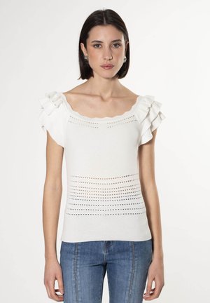 Top de punto blanco con mangas cortas acampanadas, que presenta un escote con forma de picos y detalles de ojetes horizontales a lo largo del cuerpo.