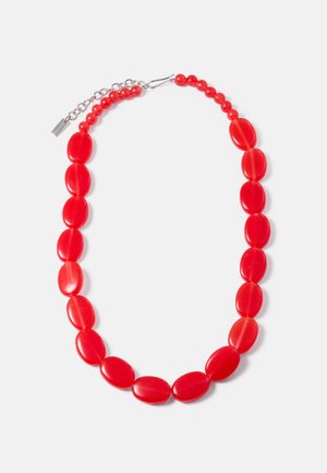 Collana di perline rosse con grandi perle ovali e piccole perle rotonde, estensore in catena argentata e chiusura ad uncino su sfondo bianco.