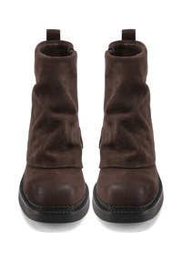 Stivaletti in suede marrone con punta liscia, design a sbuffo e suole in gomma, con un accento cucito lungo la base.