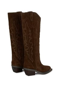 Botas de ante marrón hasta la rodilla con punta afilada, costuras decorativas en un patrón de hojas y un diseño de tacón apilado.