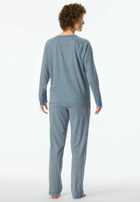 Blue pajama set featuring a long-sleeve top with raglan sleeves and matching pants, made from soft, lightweight fabric with a smooth texture.