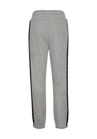 Szare spodnie dresowe z czarnymi bocznymi paskami z białymi wzorami gwiazd, elastycznym pasem i ściągaczami przy kostkach.
