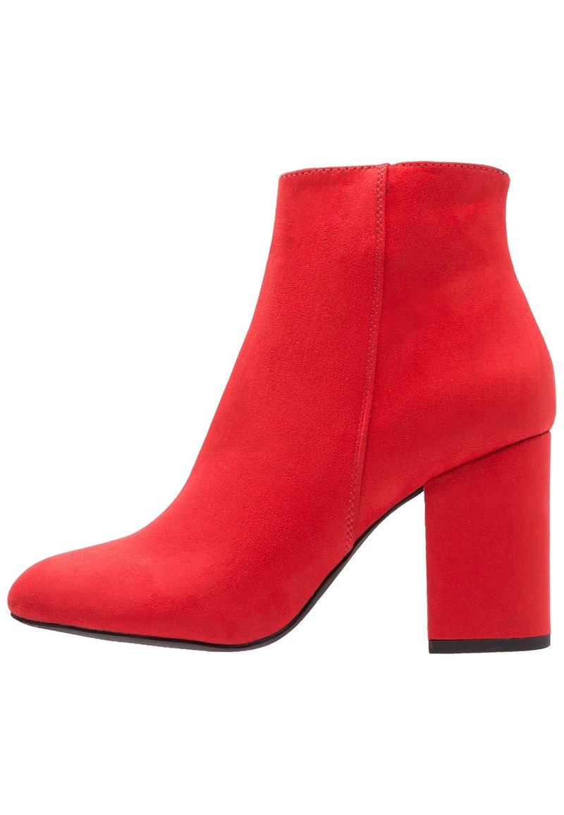 Czerwone zamszowe botki za kostkę z długim noskiem i masywnym obcasem. Charakteryzują się bezszwową konstrukcją i gładką fakturą.