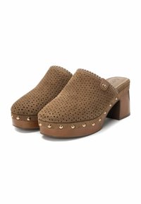 Bruine suède klompen met geperforeerd patroon, ronde neus, houten platform, goudkleurige studs langs de basis en een lage blokhak.