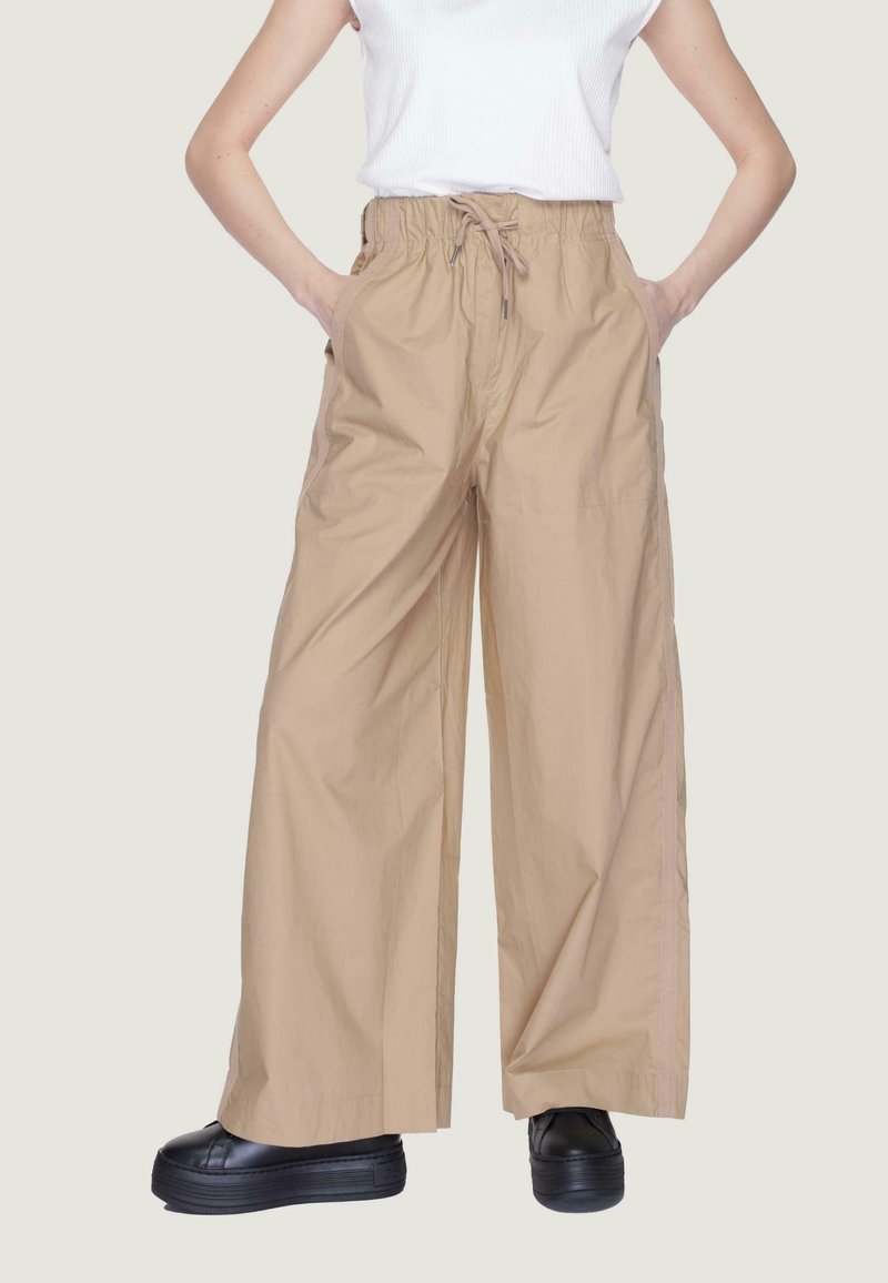 Pantaloni ampi beige con cintura elastica e coulisse. Realizzati in tessuto leggero, presentano tasche laterali e una vestibilità rilassata.