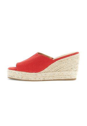 Sandale à plateforme compensée rouge à bout ouvert avec semelle en jute tressé et design à enfiler sur fond blanc.