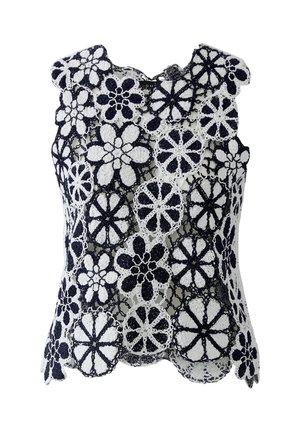 Mouwloze zwart-witte gehaakte kanten top met grote bloemmotieven en gegolfde randen.