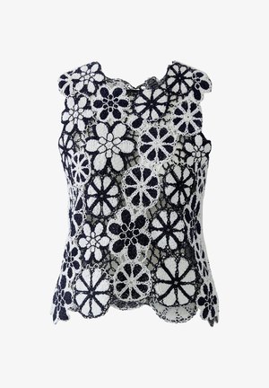 Mouwloze zwart-witte gehaakte kanten top met grote bloemmotieven en gegolfde randen.
