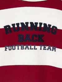 Rot-weißer gestreifter Pullover mit gesticktem Text "RUNNING BACK FOOTBALL TEAM" in Marineblau. Verfügt über einen Rundhalsausschnitt und eine weiche Stofftextur.