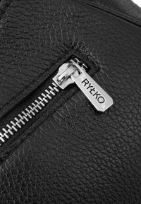 Borsa in pelle nera con superficie testurizzata, chiusura a zip argentata e una zip brandizzata con la scritta "RYŁKO".