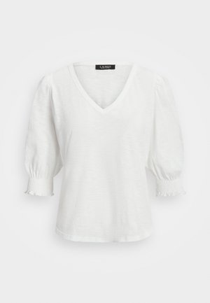 T-shirt bianco a V con maniche corte a palloncino, caratterizzato da dettagli arricciati ai polsini. Realizzato in un tessuto leggero e strutturato.