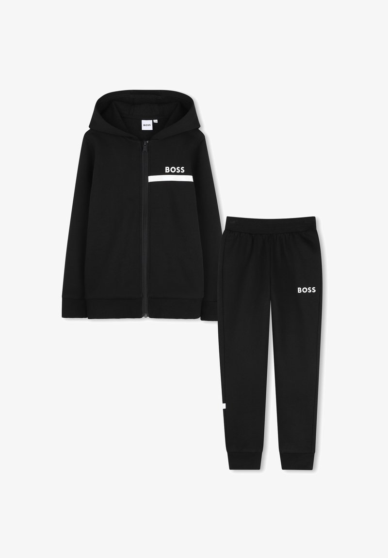 Sweat à capuche noir zippé et pantalon de jogging assorti avec le texte blanc "BOSS" et une bande sur la poitrine et la cuisse.