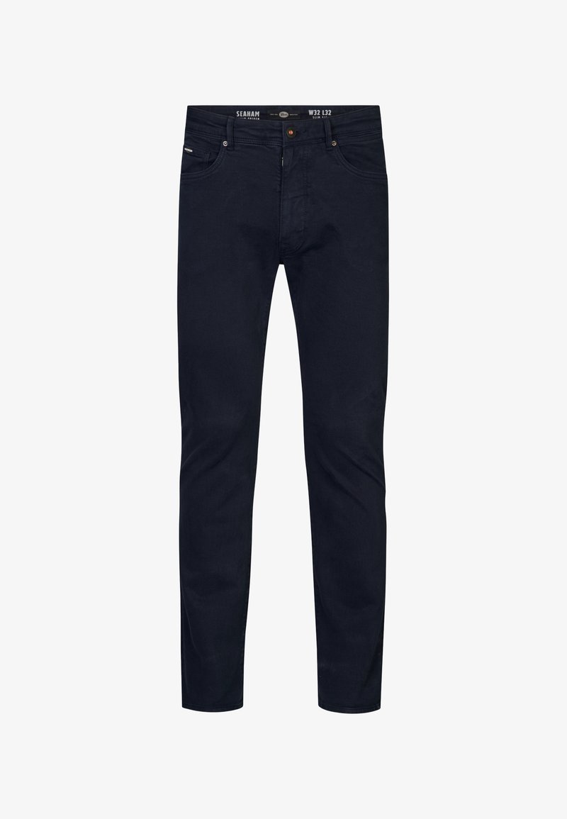 Jeans azul oscuro en corte slim, hechos de denim con una textura suave. Cuenta con cinco bolsillos y un botón de cremallera metálico.