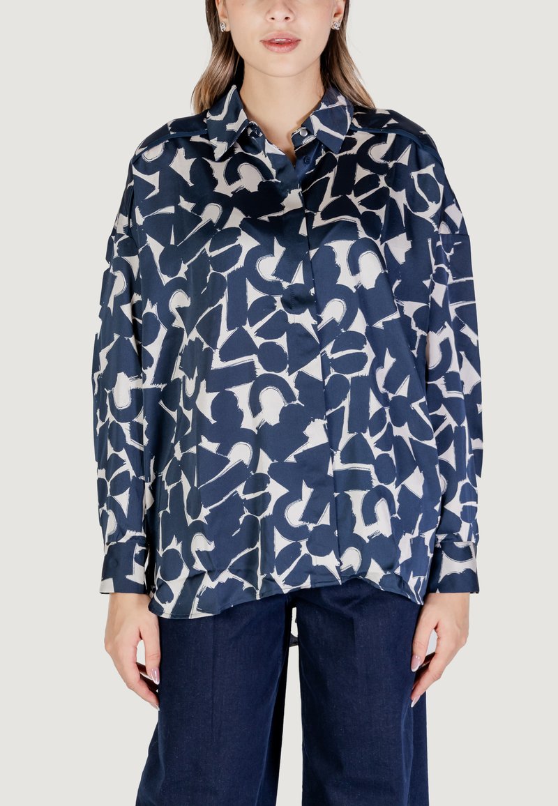 Blusa a maniche lunghe blu navy con un motivo astratto bianco, dotata di colletto e bottoni. Realizzata in tessuto leggero e morbido.