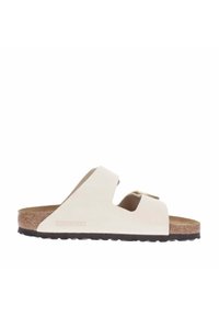 Birkenstock sandals in off-white with a cork footbed, featuring a single strap with a metal buckle and a textured black outsole.
