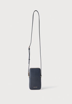 Petit sac bandoulière en cuir bleu marine avec une longue sangle réglable et une fermeture éclair dorée, logo Michael Kors en bas au centre.