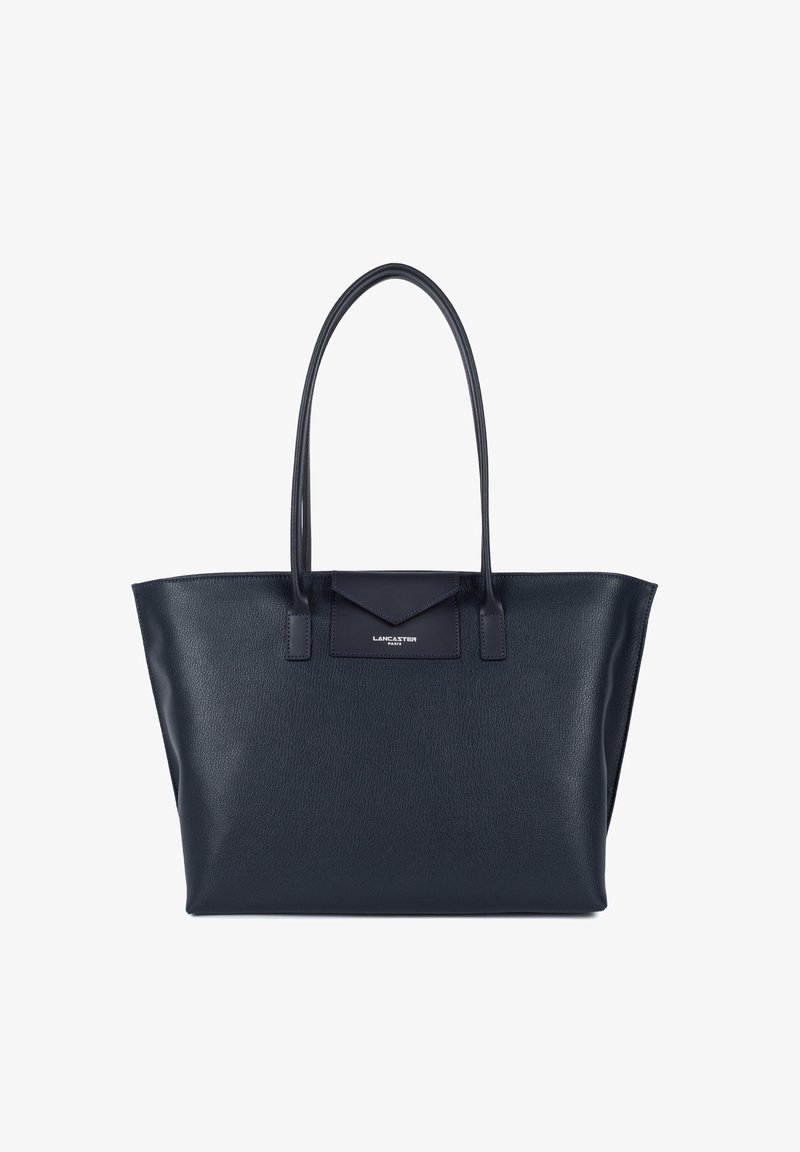 Sac en cuir navy avec de longues poignées, de forme rectangulaire et un fini texturé. Présente un logo subtil sur le rabat de la poche avant.