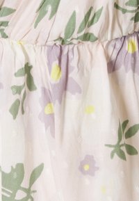 Blomstertrykt stoff i myk rosa med grønne blader og lilla blomster. Lettvektig, teksturert med svake diagonale linjer og små diamantformer.