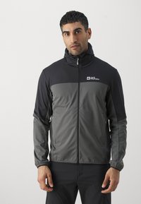 Herenjack in zwart en donkergrijs, gemaakt van lichtgewicht, rekbaar materiaal. Voorzien van een ritssluiting aan de voorkant, een capuchon en zijzakken. Merklogo weergegeven.