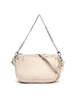 Mała beżowa skórzana torebka z srebrnym łańcuszkiem i regulowanym paskiem, wyposażona w zamykane na zamek przegrody i zaokrąglone krawędzie.