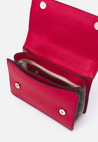 Rote Lederbrieftasche mit offenem Deckel, der mehrere Fächer und ein beiges Innenfutter mit Reißverschlusstasche zeigt, auf weißem Hintergrund.