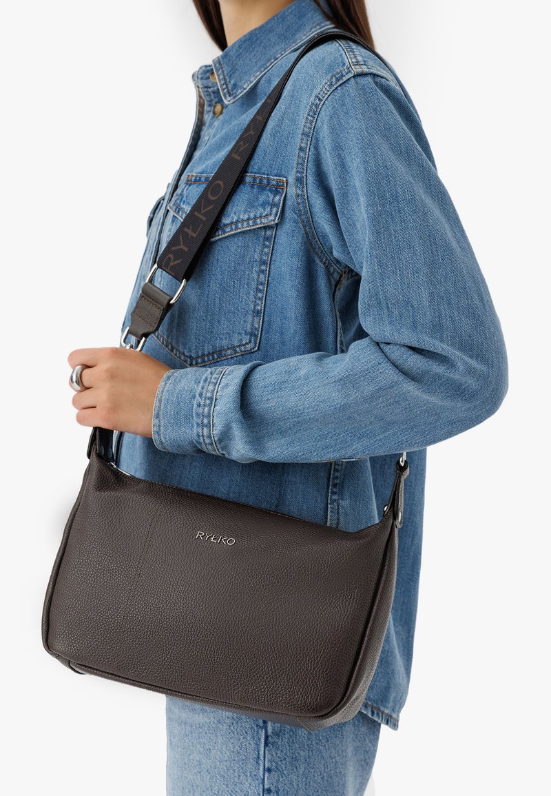 Borsa a tracolla in pelle marrone a graniglia con una texture liscia, dotata di una tracolla nera con dettagli del logo e una forma rettangolare elegante.