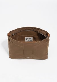 Bolsa tote de tela marrón con cierre de cremallera, que incluye una etiqueta interior y un diseño elegante. El exterior presenta detalles sutiles de costura.