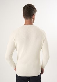 Strickpullover in Off-White, mit gerippter Textur, langen Ärmeln und einem klassischen Rundhalsausschnitt-Design mit geradem Saum.