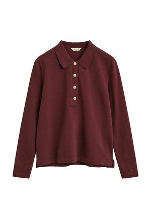 Polo a maniche lunghe di colore bordeaux con colletto e quattro bottoni dorati centrati sul petto.