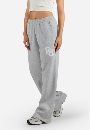 Grå sweatpants tillverkade av mjukt tyg, med en avslappnad passform, elastisk midja och vitt logotypdetalj på vänster ben.