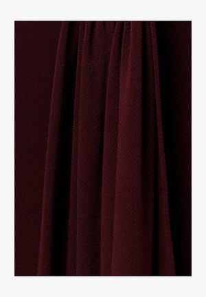 Tume burgundia värvi plisseeritud kangas, millel on tekstuuriga ja pehme välimus, luues vertikaalseid voldikuid ja varje.