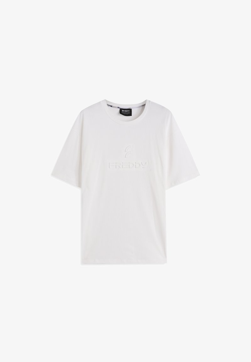 Camiseta de algodón blanca con cuello redondo, mangas cortas, con un logo en relieve de "FREDDY" en el frente. Textura suave y ajuste relajado.
