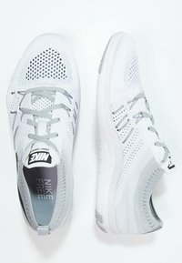 Lekki, oddychający szary meshowy sneakers, z teksturowaną górą, sznurowadłami, amortyzowaną podeszwą i marką Nike na języku.