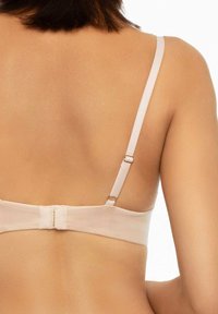 Jasnoróżowy biustonosz z regulowanymi ramiączkami i zapięciem na haczyk. Gładki materiał z minimalnymi zdobieniami, prezentujący bezszwowy design pleców.