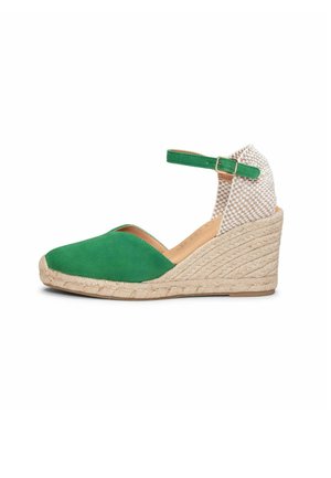 Sandalia de cuña tipo espadrille verde con puntera cerrada, tacón tejido beige y correa al tobillo con hebilla dorada sobre fondo blanco.
