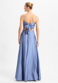 Langes, blaues Satin-Kleid mit dünnen Trägern, einem verschnürbaren Detail, Ausschnitten und einer glatten, fließenden Silhouette.