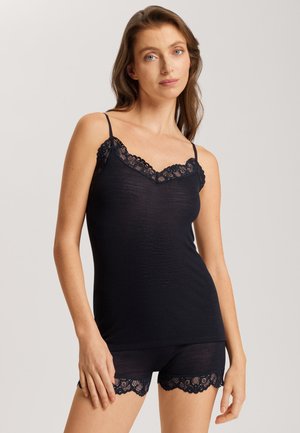 Navy ribbed camisole with adjustable straps, featuring a scalloped lace trim at the neckline and matching lace-accented shorts.