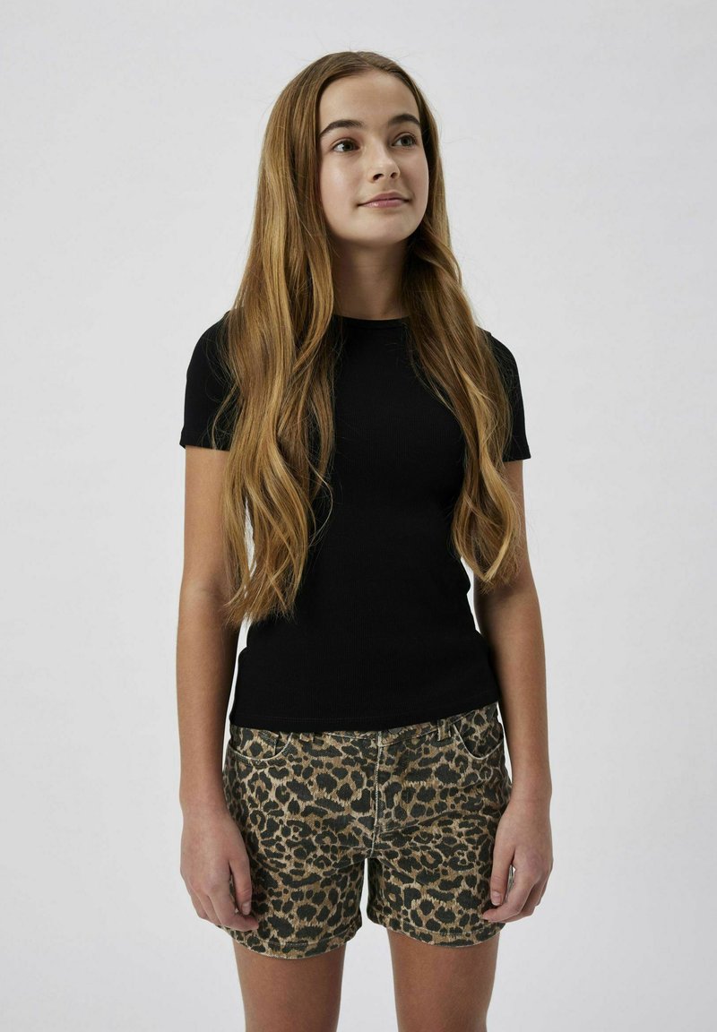 Svart ribbad kortärmad topp i kombination med shorts i leopardmönster. Shortsen har en strukturerad mönstring och standardfickor.