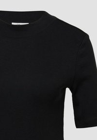 Czarna koszulka z krótkim rękawem, wykonana z elastycznej bawełny. Posiada okrągły dekolt i gładką, równą teksturę. Minimalistyczny design bez wzorów.