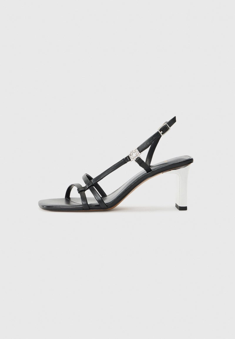 Melni papēžu sandales ar vairākiem šauriem siksniņām, slingback dizains un sudraba akcenti uz papēža. Gluda augšējā materiāla un kvadrātveida papēdis.