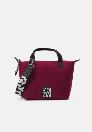 Borsa tote DKNY in bordeaux scuro con manici in pelle nera, tracolla staccabile e patch logo bianco. Tessuto strutturato con forma definita.
