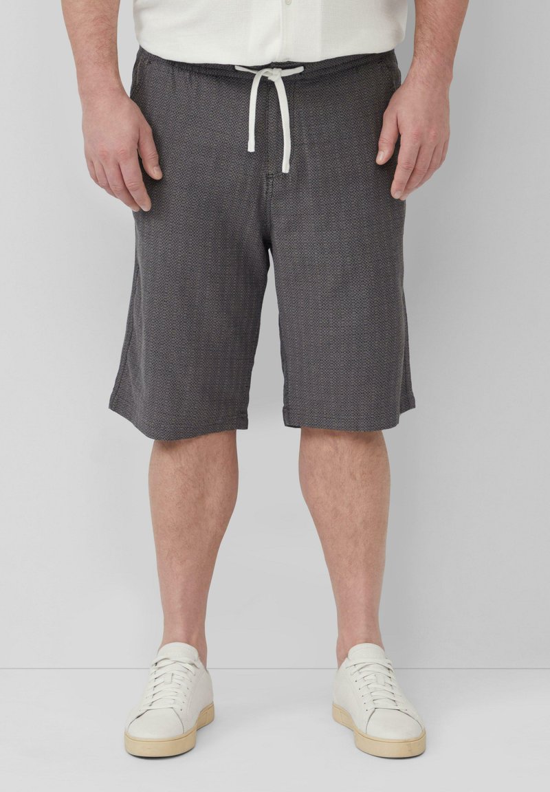 Heren shorts in donkergrijs, textuurstof, elastische tailleband met witte trekkoord, rechte snit en gezoomde randen, gecombineerd met witte sneakers.
